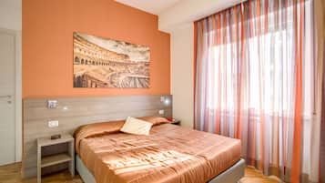 Un dormitorio con cama, mesita de noche, lámpara de pared y ventana con cortinas traslúcidas.