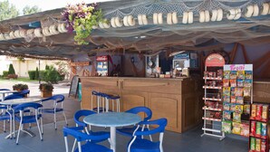 An outdoor café with blue chairs and a wooden counter. - Central Plaza Apart Hotel (Sunny Beach)