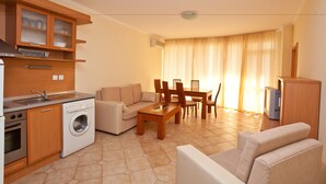 A compact living space with a kitchenette, a sofa, a dining table, and a TV. - Central Plaza Apart Hotel (Sunny Beach)