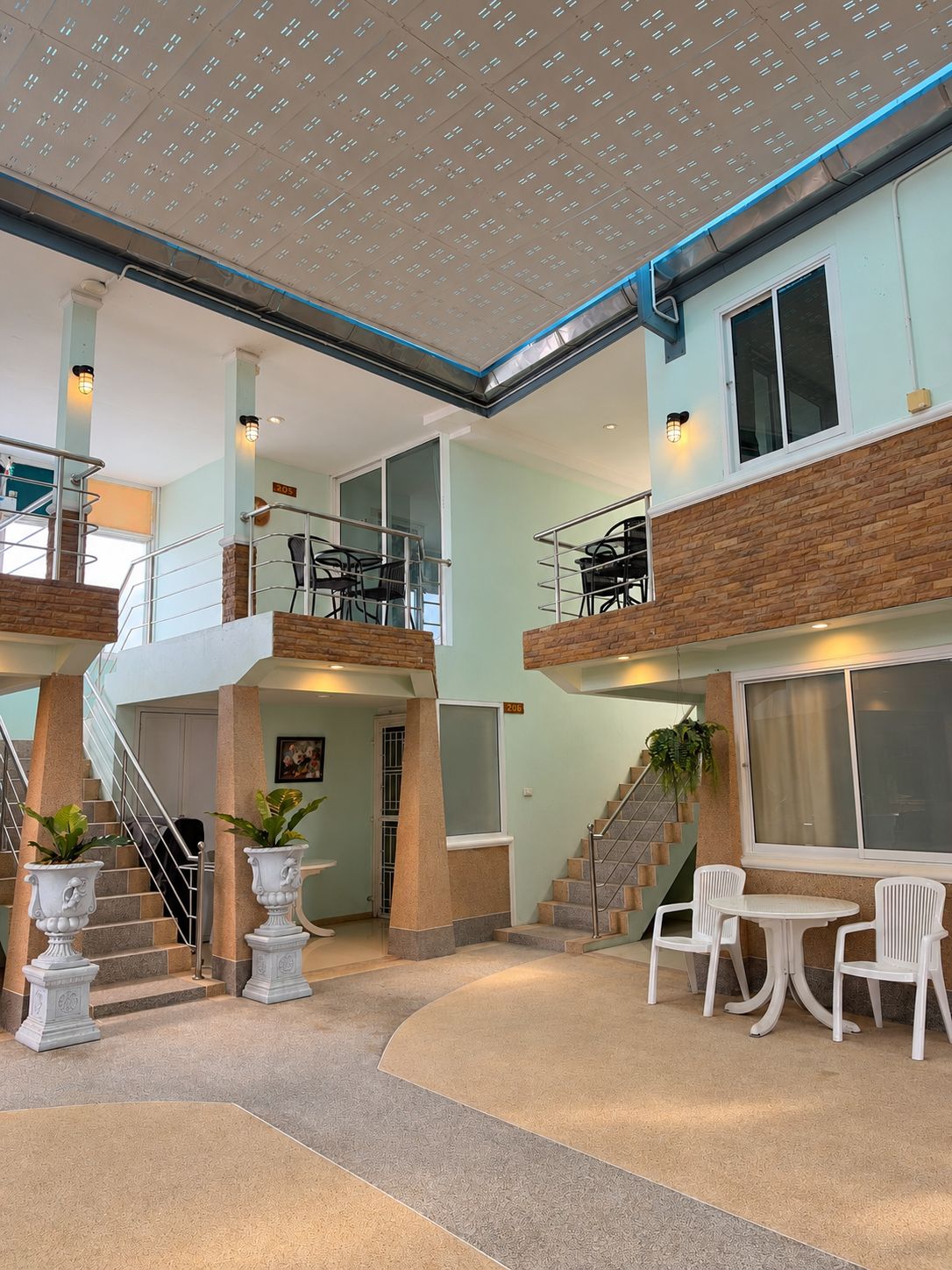 Un espace intérieur à plusieurs niveaux, doté d’un escalier, d’un coin salon et offrant une vue sur l’extérieur.