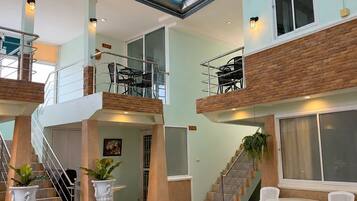 A multi-level indoor space with a staircase, seating area, and a view of the outside.