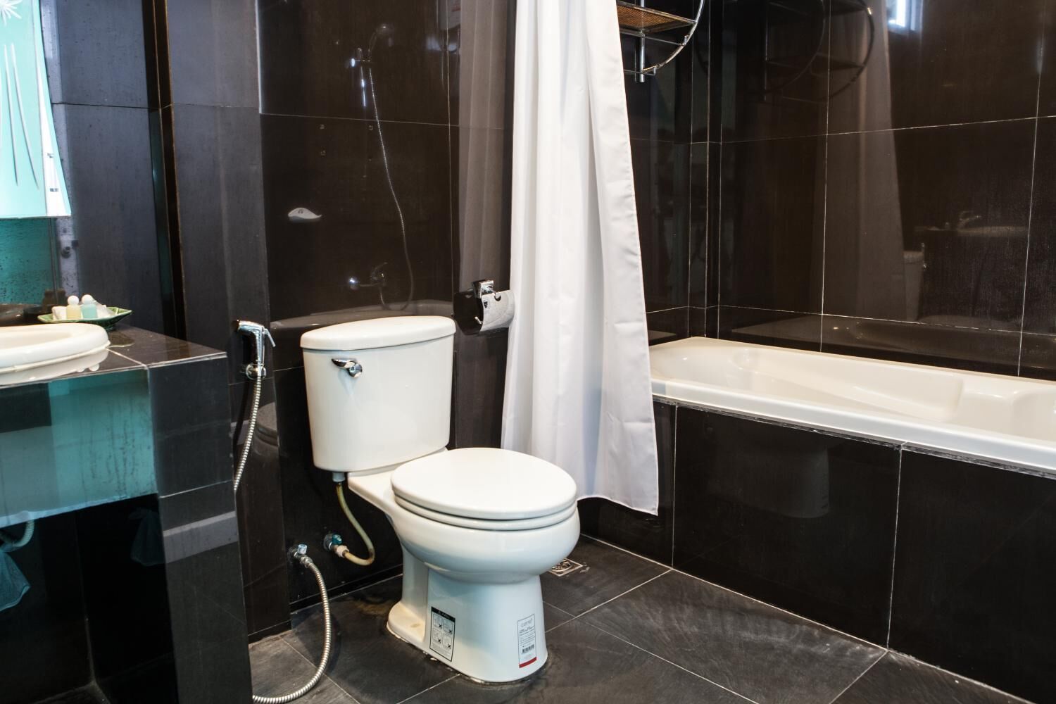 Une salle de bain moderne équipée de toilettes, d’un lavabo et d’une baignoire.