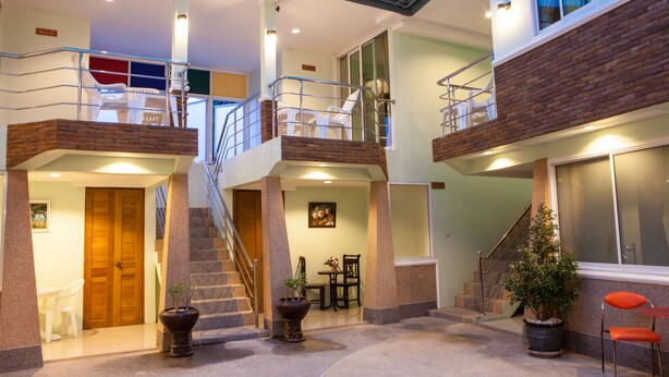 Un'ampia area interna con soffitto alto, una scala e diverse zone relax.