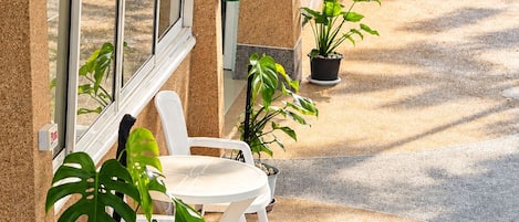 A hotel exterior with a brick facade, outdoor seating, and potted plants.