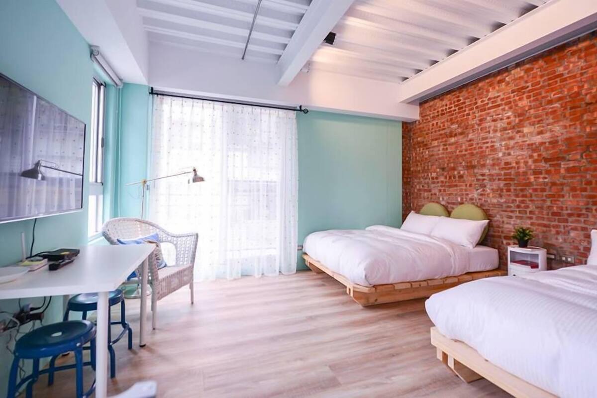 Une chambre moderne avec deux lits, un bureau et une chaise.
