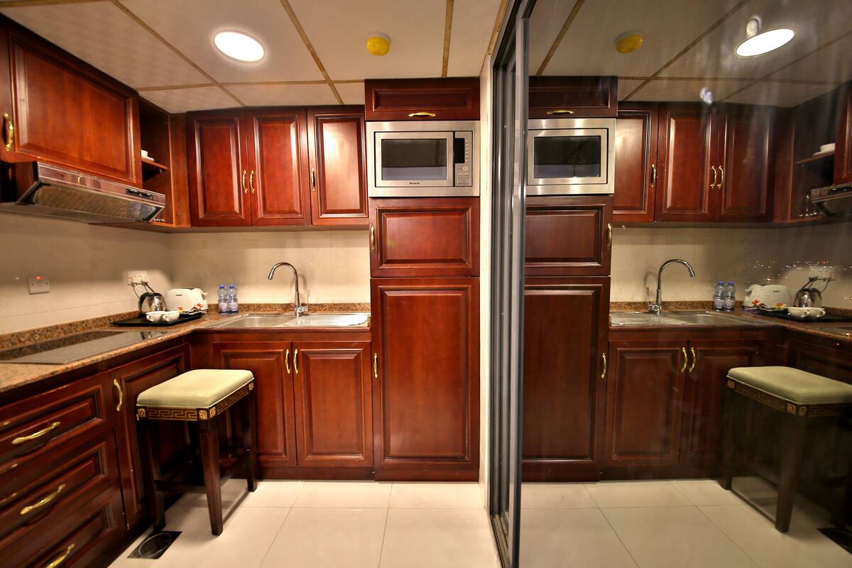 A kitchen with wooden cabinets, stainless steel appliances, and a double sink.