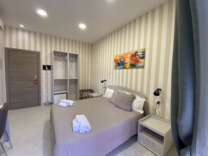 A hotel room with a bed, a wardrobe, a desk, and a painting on the wall. - 2Naples rooms (Naples)