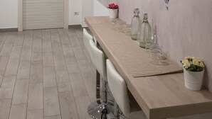 A modern interior with a long wooden table, white chairs, and a world map mural on the wall. - 2Naples rooms (Naples)