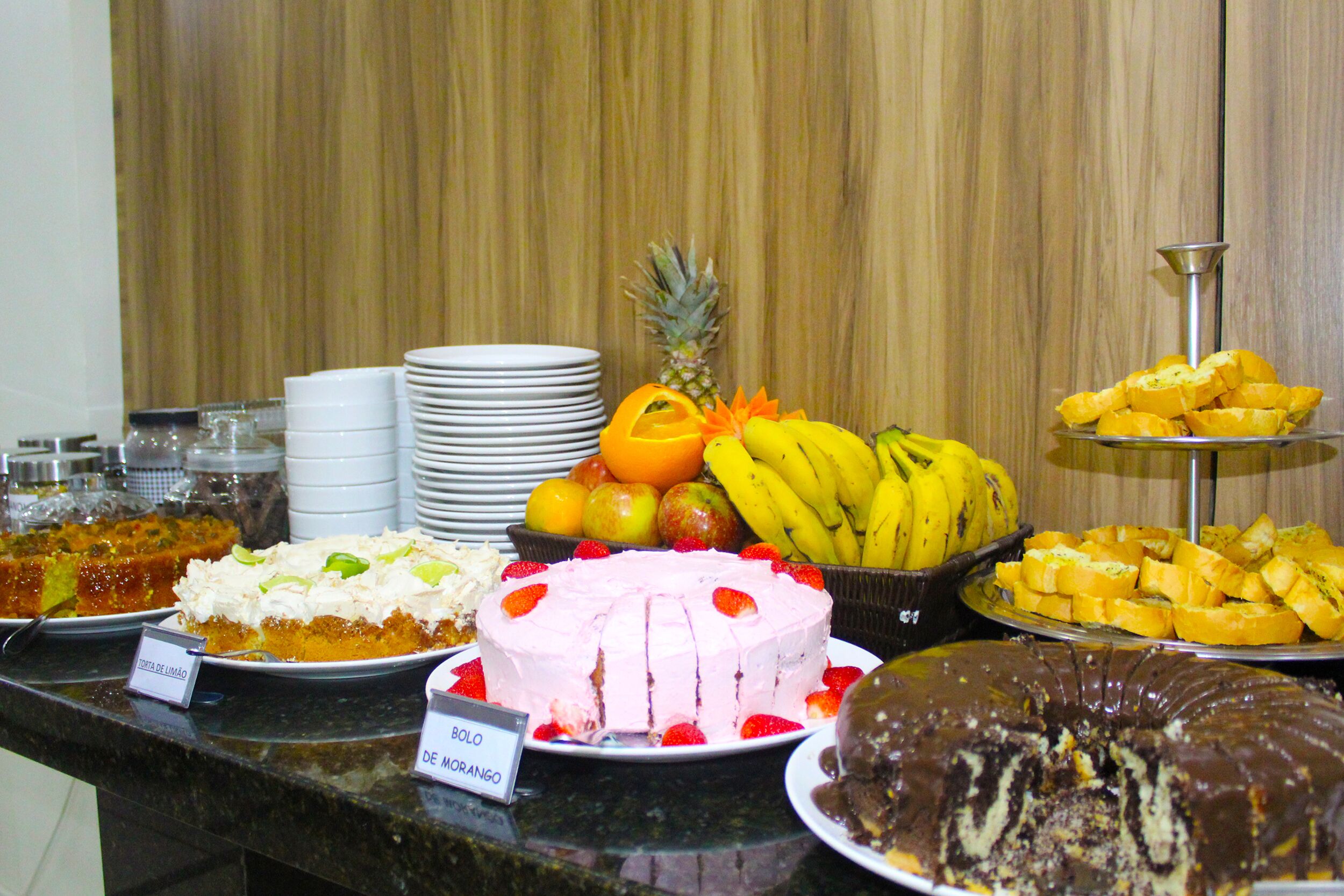 A buffet with various desserts and fruits.