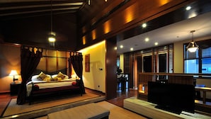 Una habitación de hotel con cama, televisión, escritorio y zona de comedor.