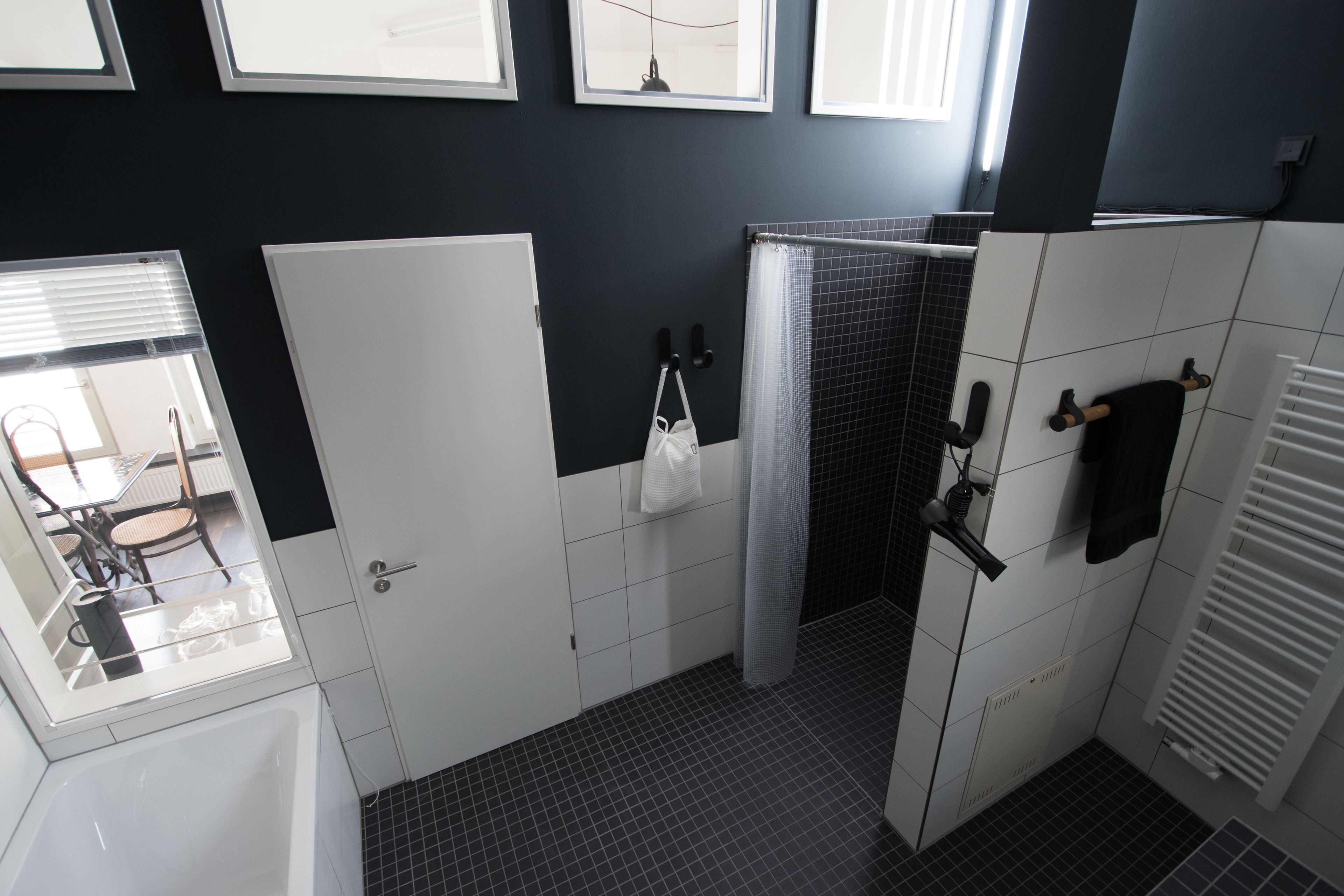 A bathroom with a shower, a towel rack, and a toilet.