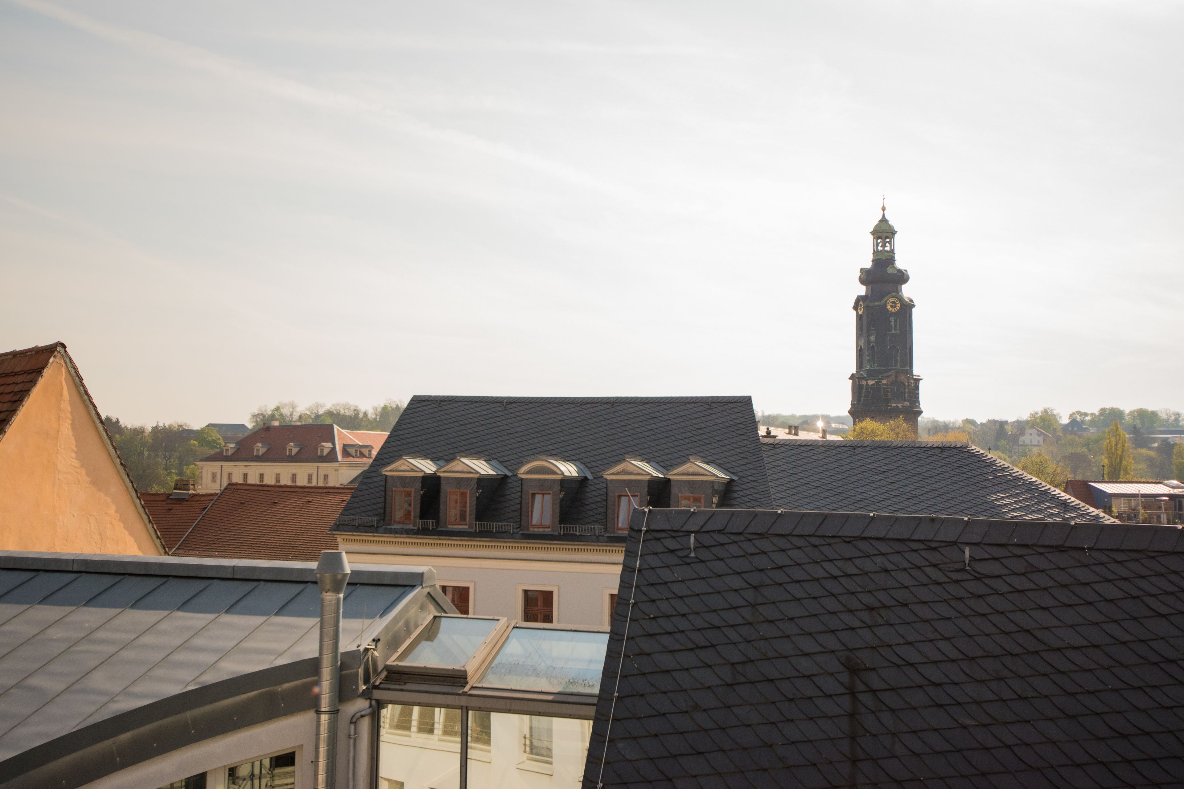 A building with a prominent clock tower and multiple rooftops.