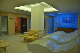 Un moderno spa con una banca de madera, una camilla de masaje y un mostrador de recepción.