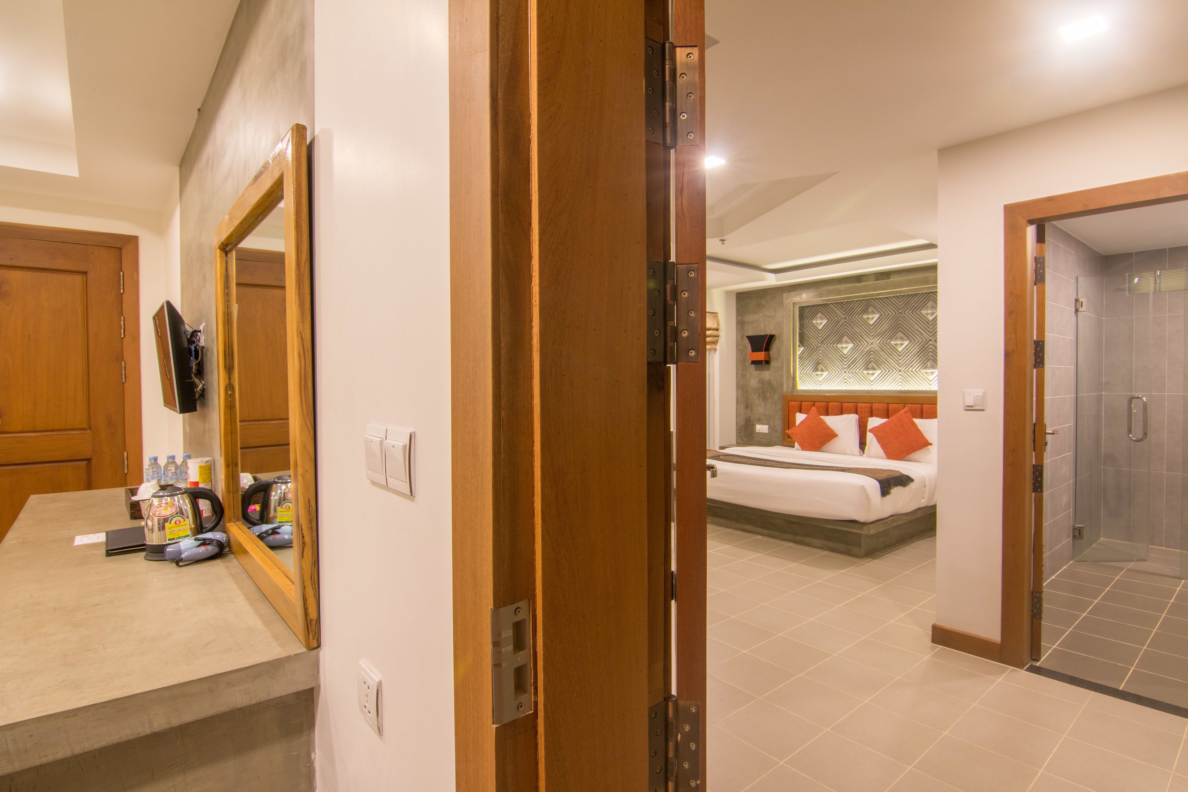 A hotel room with a bed, a bathroom, and a kitchenette area.