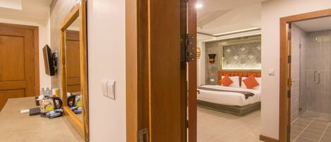 A hotel room with a bed, a bathroom, and a kitchenette area.