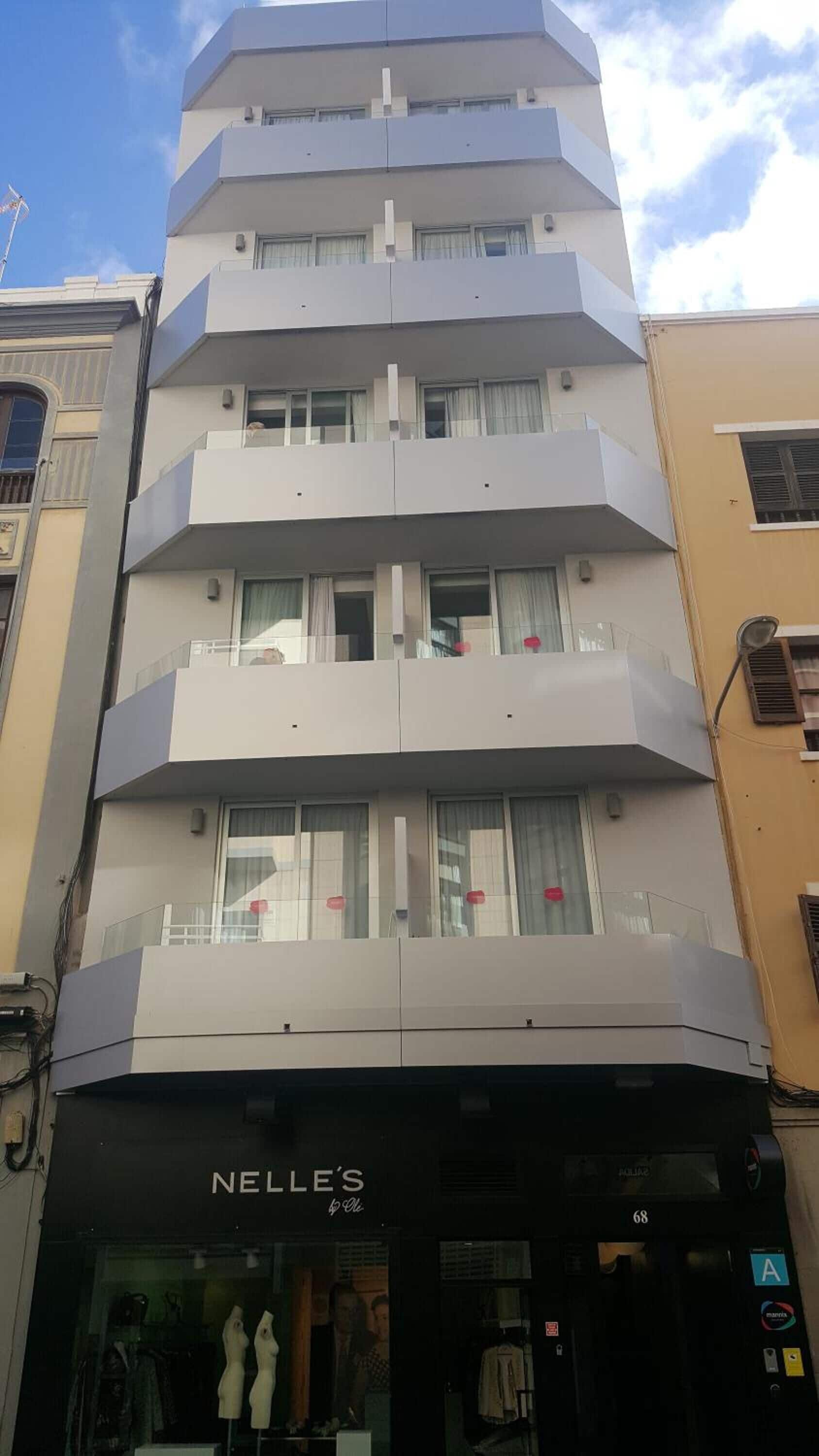 Un edificio de varios pisos con una tienda Nelles en la planta baja.