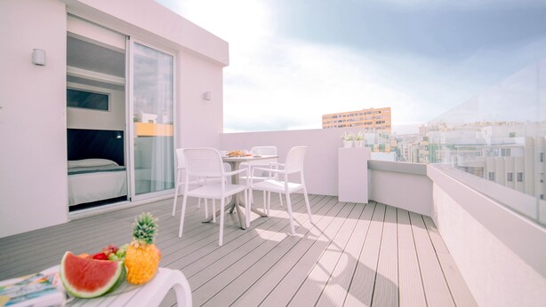 A balcony with a table, chairs, and a fruit display. - Mannix Urban Apartments (Las Palmas de Gran Canaria)