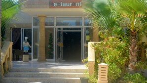 A restaurant with a sign above the entrance, a statue of a chef, and steps leading up to the door. - The Ksar Djerba Charming Hotel & SPA (Djerba Midun)