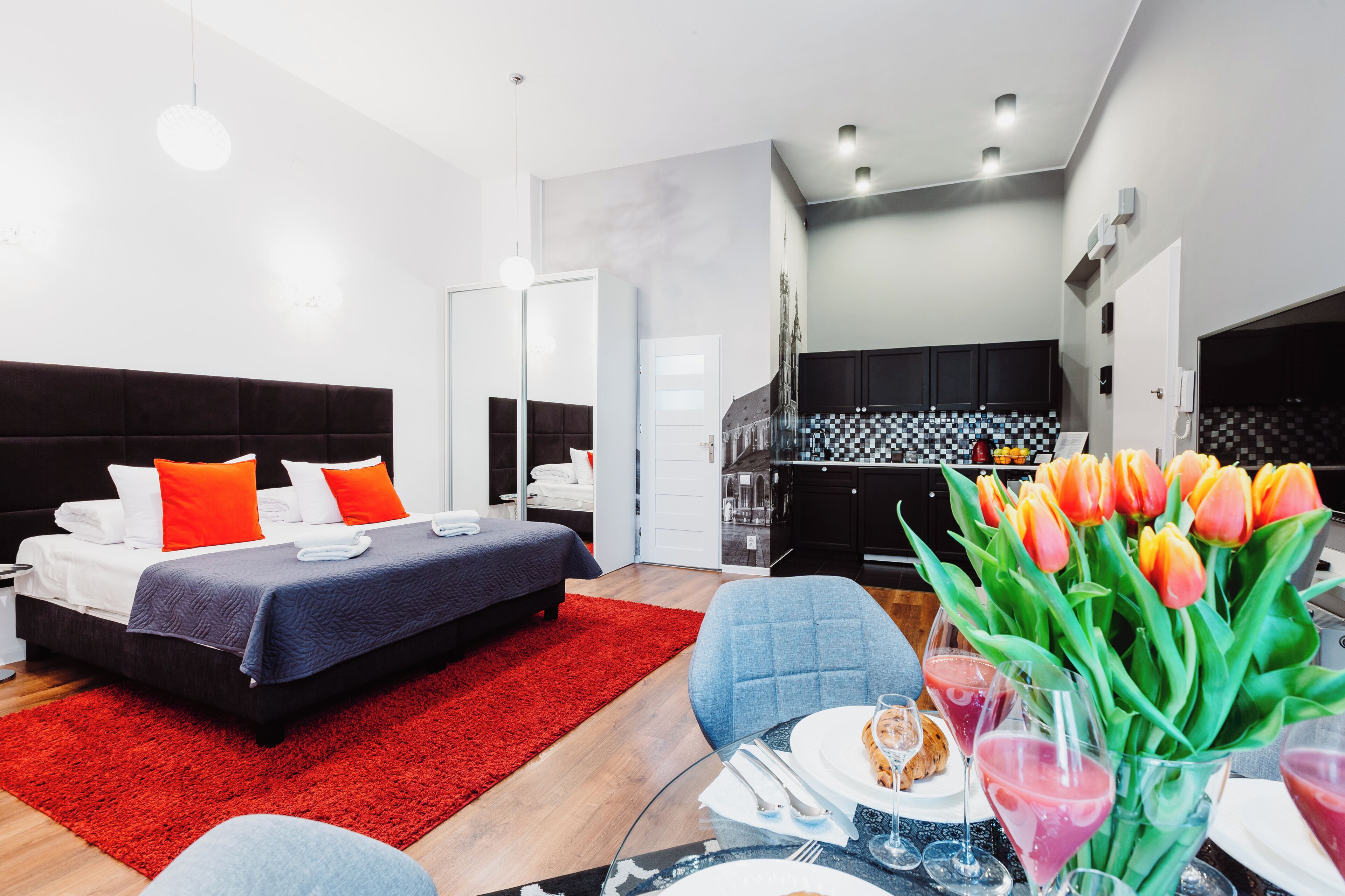 Ein modernes Hotelzimmer mit Bett, Essbereich und Küche.