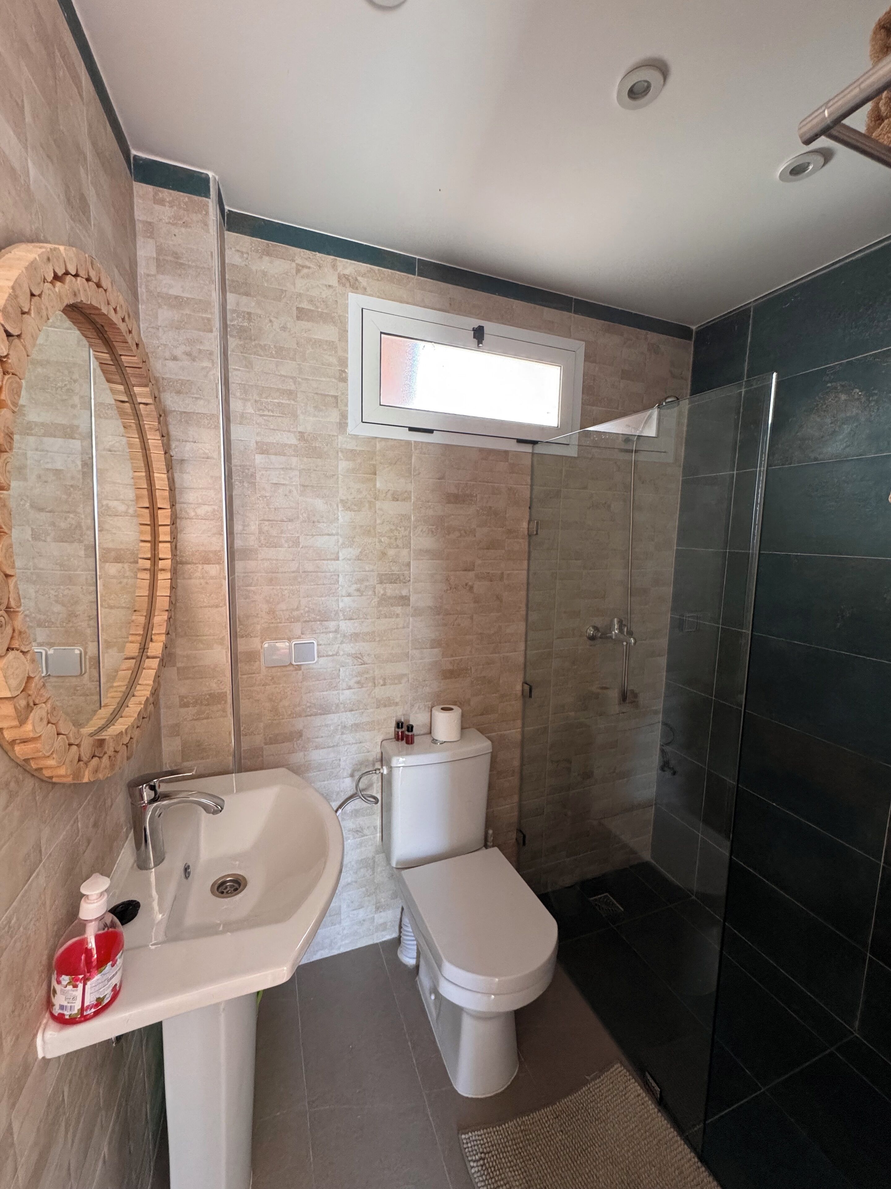 Un baño moderno con lavabo, inodoro y ducha.