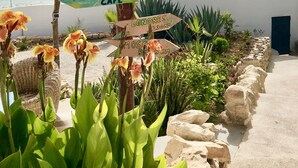 Een houten bord met richtingsaanduizingspijlen naar verschillende bestemmingen, zoals Ushuaia, Banana Beach, Biarritz, Ocean Cafe, Londen en Mosel.