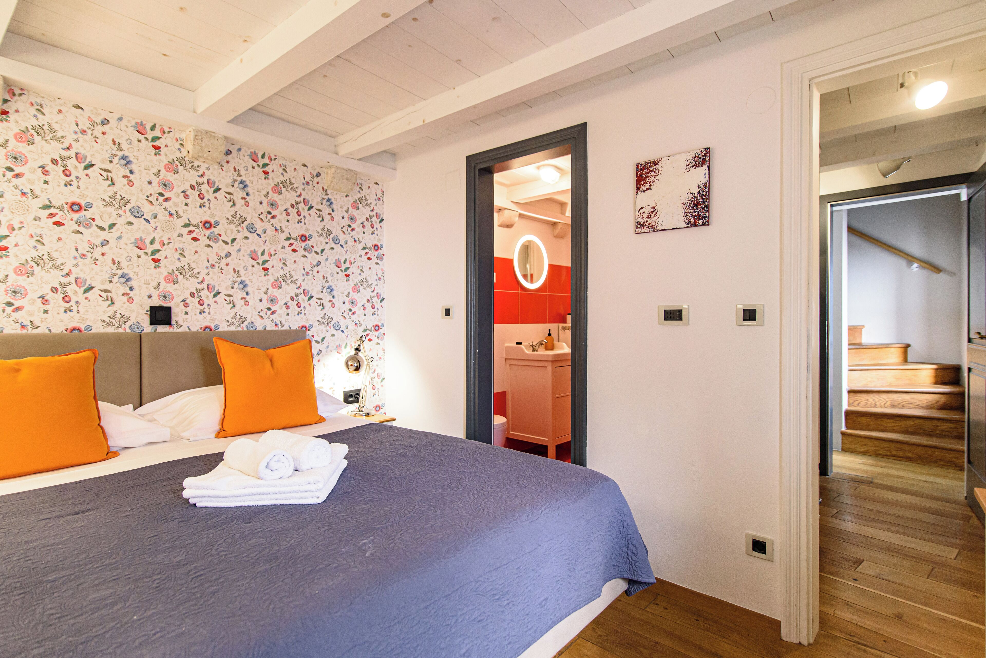 Un dormitorio con una cama, almohadas y una colcha azul.