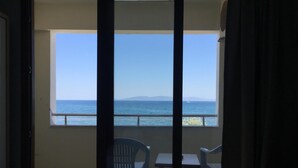 Un balcó amb vista al mar i a les muntanyes llunyanes. Hi ha dues cadires i una taula petita.