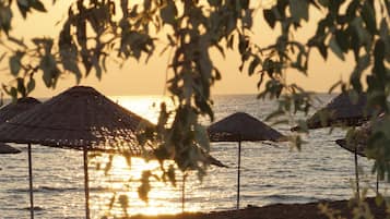 Playa privada, sillas reclinables de playa, sombrillas