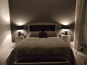 A bedroom with a large bed, two bedside tables with lamps, and a headboard with a dark panel. - Hotel la Réserve (Gerardmer)