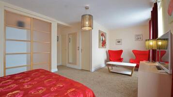 Une chambre d’hôtel avec un lit, un bureau, une chaise et une armoire.
