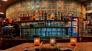 A bar area with a variety of liquor bottles, a coffee machine, and a glass display case. - Hotel la Réserve (Gerardmer)
