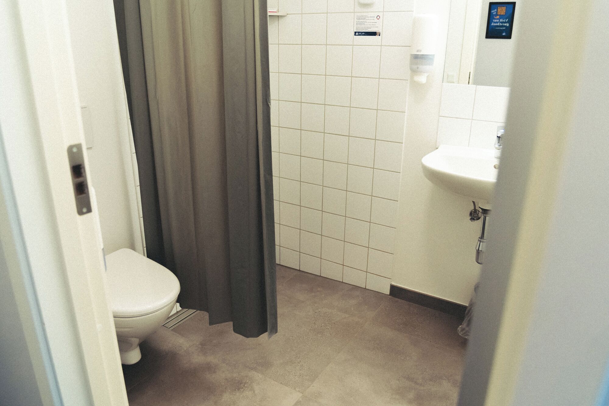 Un baño pequeño y limpio con inodoro, cortina de ducha y lavamanos.