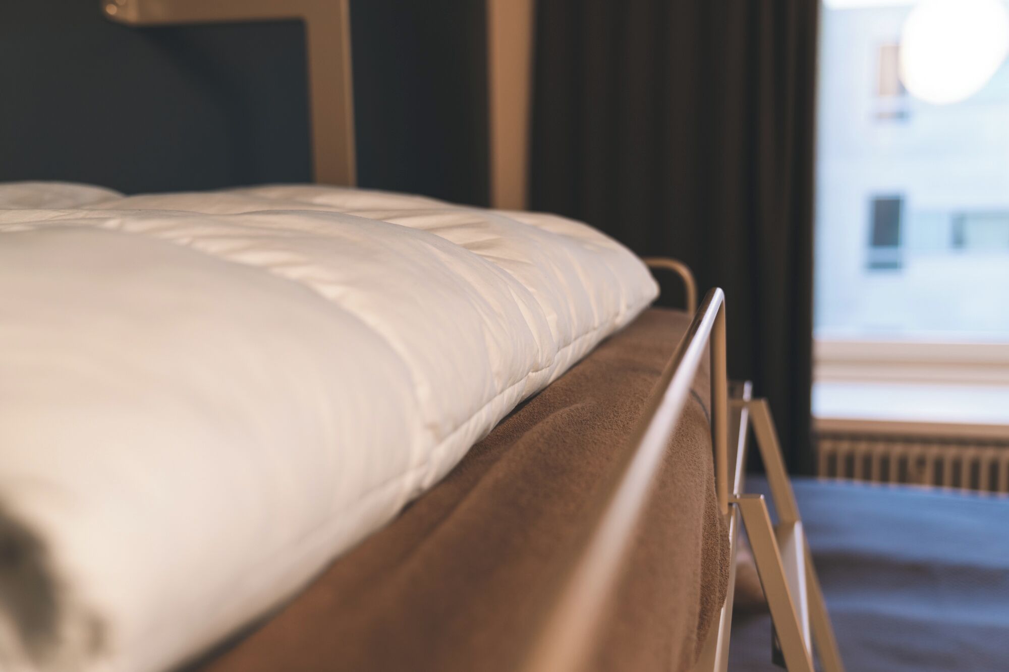 Una cama con cabecera de madera y colchón blanco.