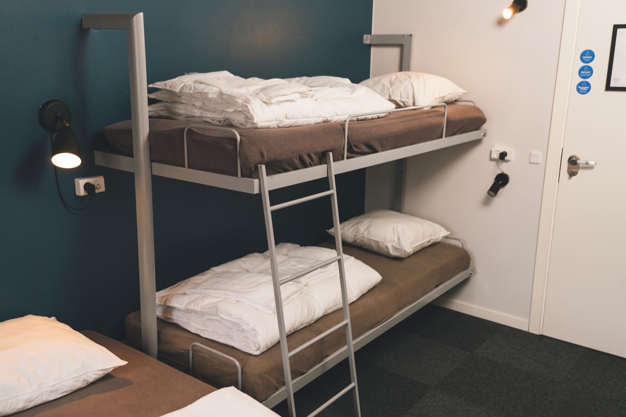 Habitación con literas, un escritorio y una puerta con cerradura.