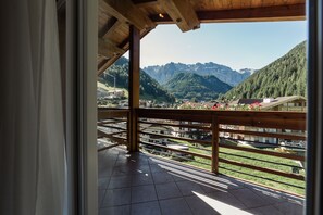 A balcony with a wooden railing overlooking a mountainous landscape. - Hotel Freina (Selva di Val Gardena)