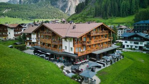 Un hotel con fachada de madera, varios balcones y zonas de estar al aire libre.
