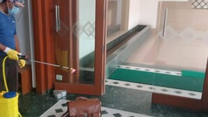 Uma pessoa limpando um vidro com um borrifador e um pano.
