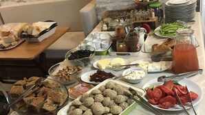 A buffet table with various food items and condiments.