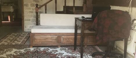 A staircase with wooden railings, a patterned rug, and a wooden desk with a chair.