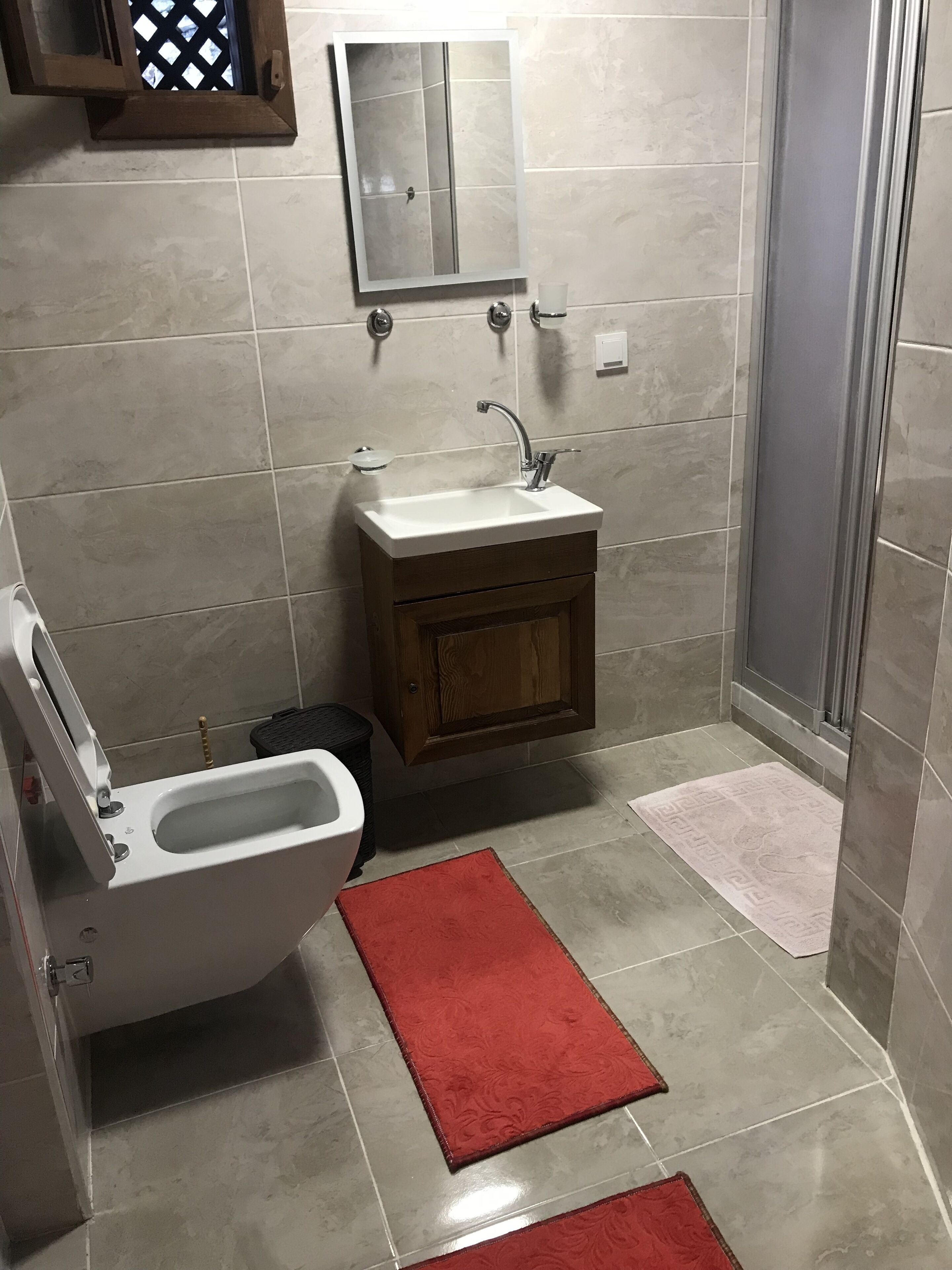 Un baño con inodoro, lavamanos y ducha.