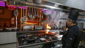 A chef cooking with a flame visible in a professional kitchen. - Exelans Hotel (Fethiye)
