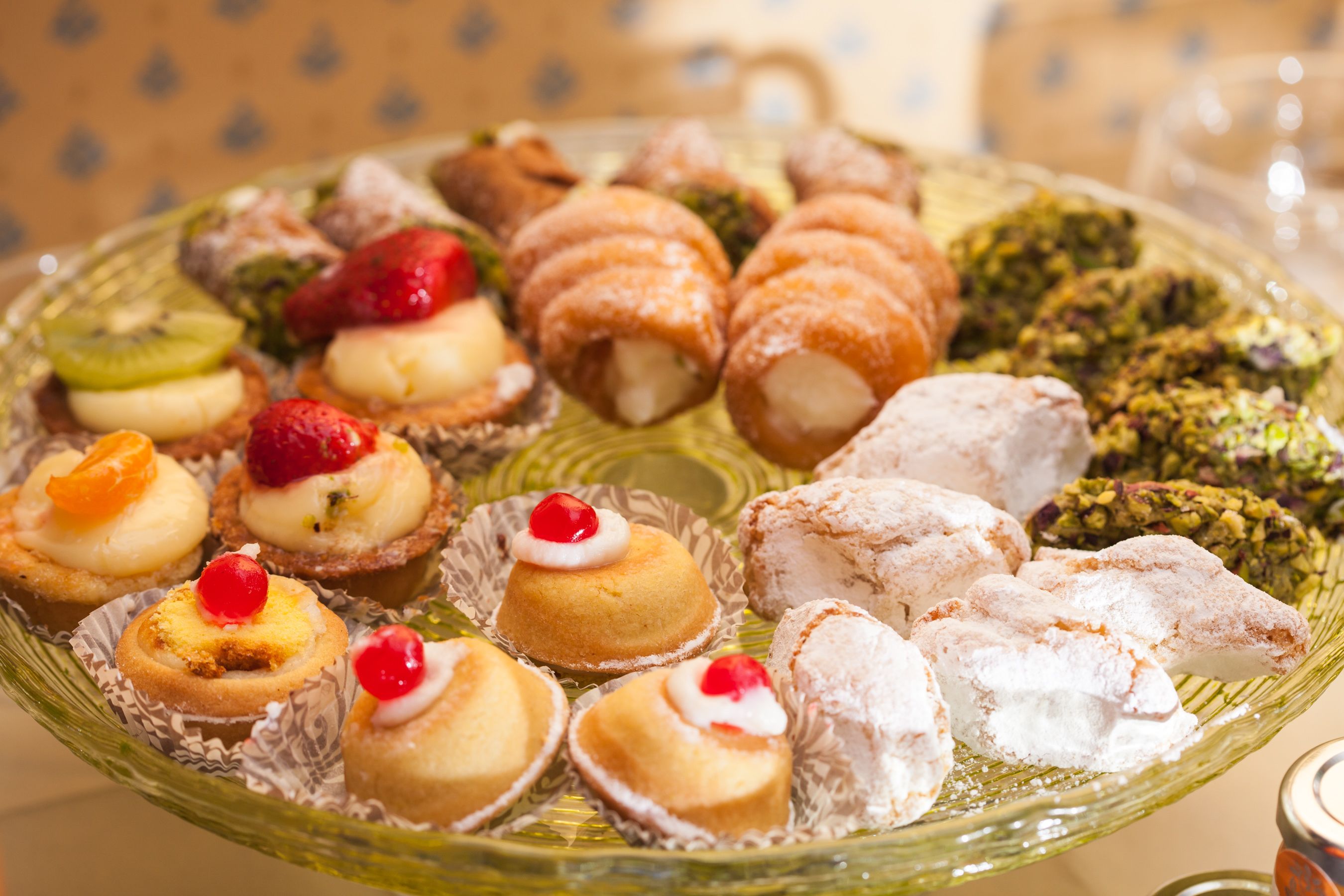 A variety of pastries and desserts on a glass plate.