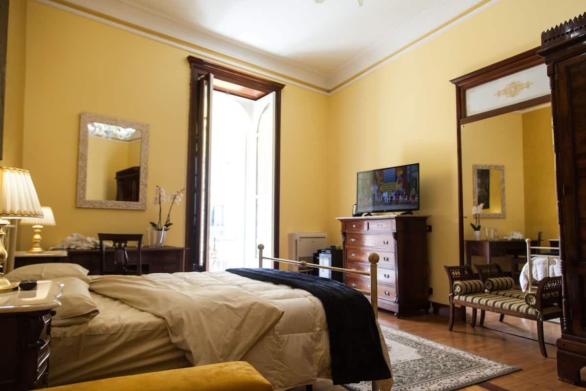 A hotel room with a bed, a television, a dresser, and a chair.
