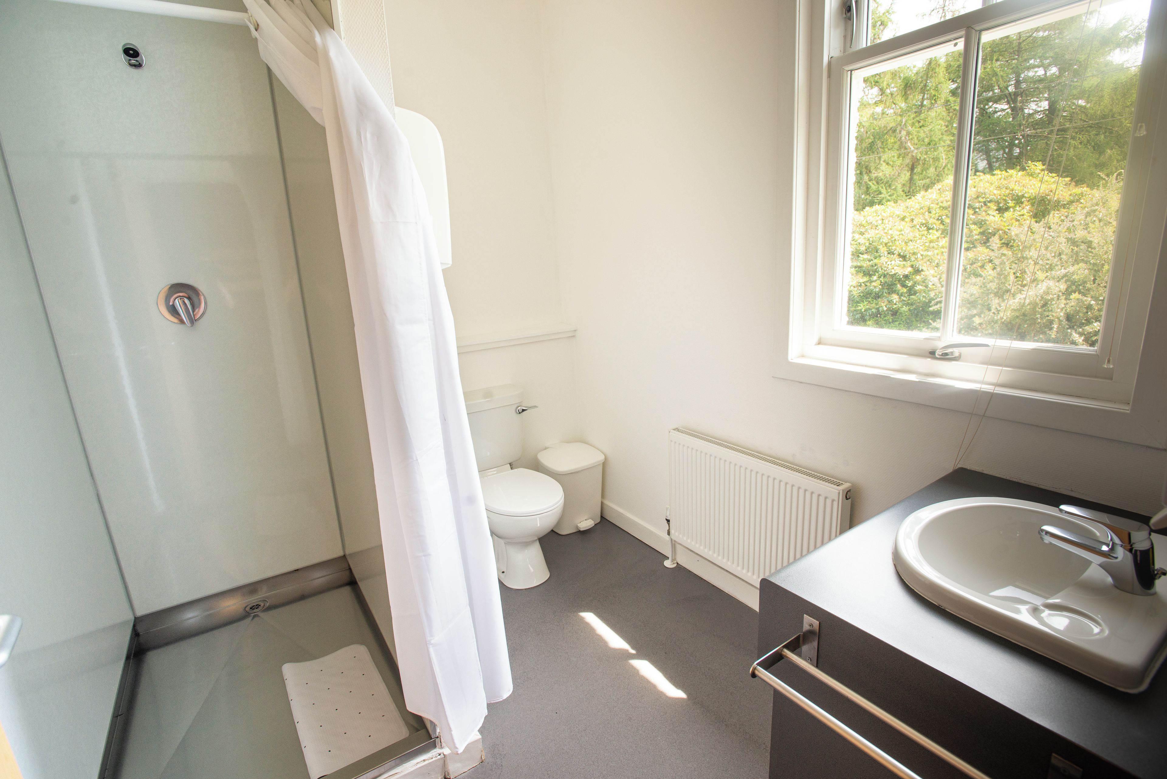 A bathroom with a shower, toilet, and sink.