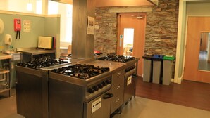 Una cocina con una estufa grande, una pared de piedra y una puerta de madera.