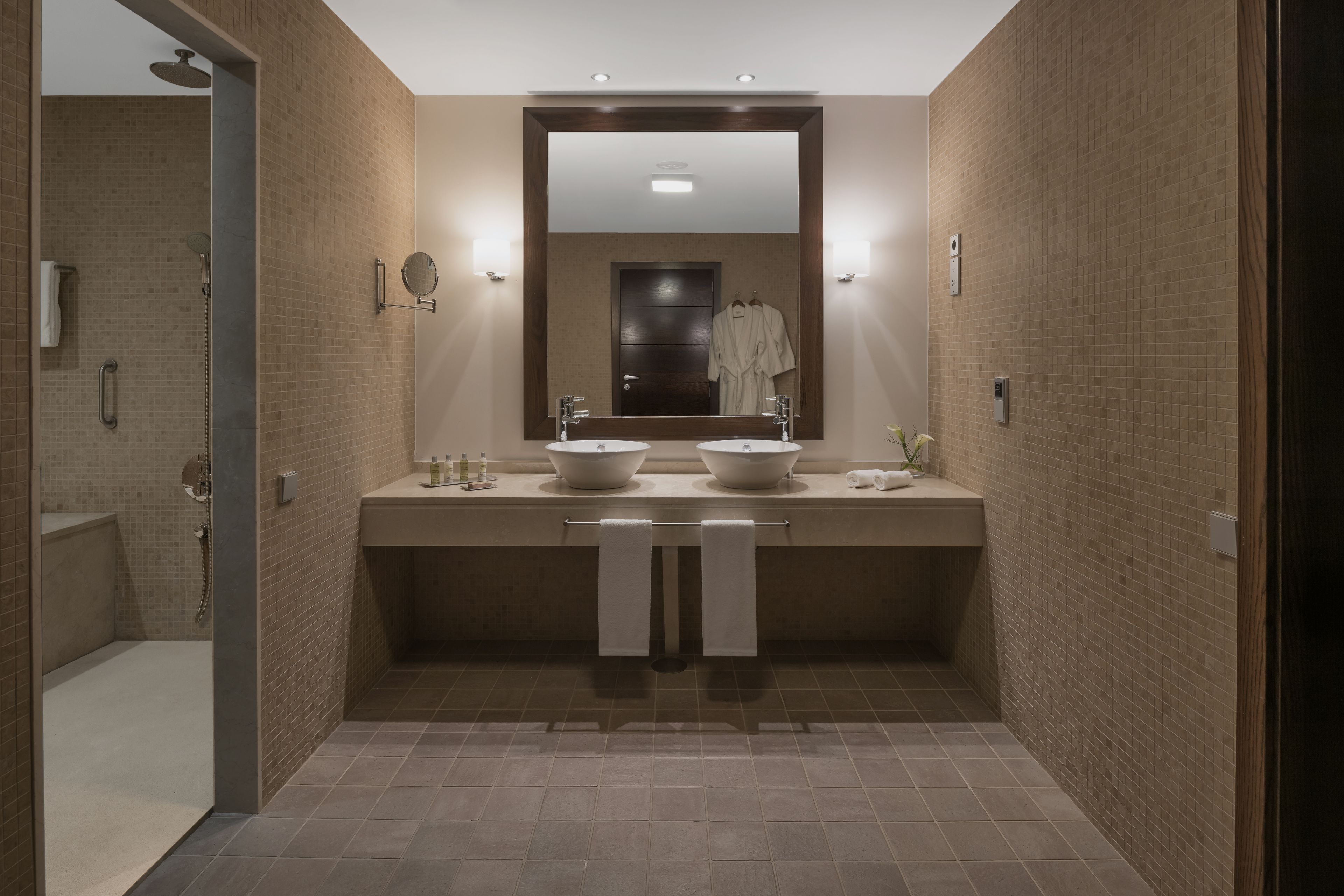 Een moderne badkamer met twee wastafels, een grote spiegel en een inloopdouche.