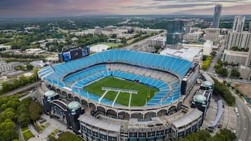 A large stadium with a circular design, surrounded by modern buildings and roads.