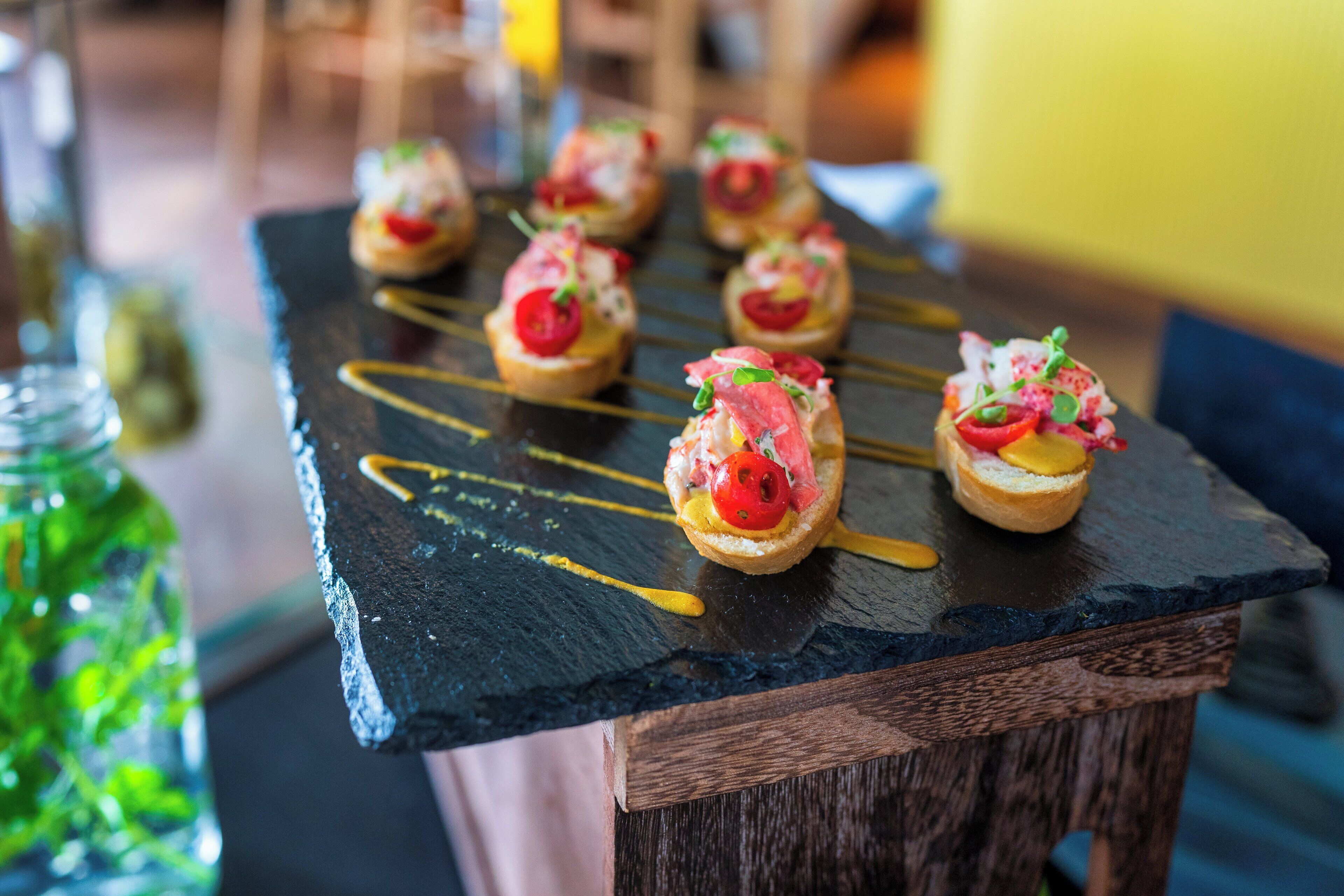 Una tabla de pizarra con aperitivos dispuestos sobre ella.
