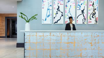 Eine Rezeption mit abstrakter Wandkunst, einer Zimmerpflanze und einem modernen Interieur.