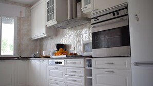 A kitchen with white cabinets, a microwave, and a stove. - La Casa de Manuel (Portomarin)
